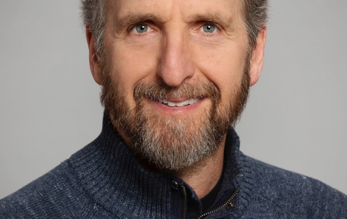 Image of Dan Wolpert. Dan has a friendly, bearded smile. He is wearing a blue/grey sweater.
